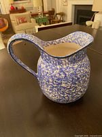 three-quarter view of blue and white spongeware jug on table