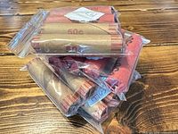 Stack of zip bags containing brown and red bank-wrapped penny rolls