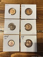 Front view of all six coin flips displaying dates 1909 (2), 1909 VDB, 1947, 1948, 1958