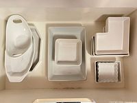 Top-down view of all white porcelain pieces arranged in cabinet