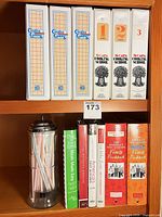 Shelf with cookbooks and glass straw dispenser