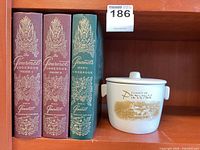 Books and ceramic pot together on shelf