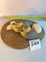 Top view showing full sculpture with medallion and tape for scale