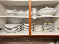 Full set on cabinet shelves showing dinner plates, salad plates, soup bowls, gravy boat, creamer, sugar bowl, tureen, open serving bowl