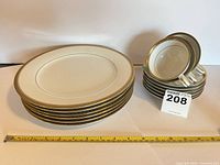 Stack of six dinner plates and stack of small plates with tape for scale