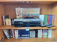 Pioneer receiver, Panasonic DVD player, remotes, VHS tapes and DVDs on shelf