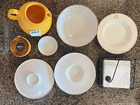 All ten dinnerware and accessory pieces arranged on countertop