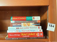 Stack of all seven cookbooks showing spines