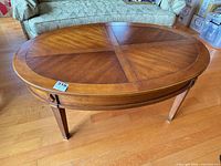 Full view of oval veneer coffee table showing top surface and overall form