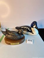 Bronze and wood duck decoys side by side
