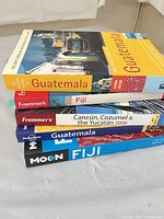 Stacked view of all five travel guide books showing covers and spines