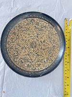 Front view of brass enamel wall plate with measuring tape showing 10 in diameter