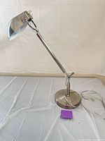 Full view of brushed nickel desk lamp showing adjustable arm and dome shade