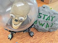 Skull animatronic globe beside tombstone