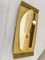 Knife body and serrated blade seated in brown storage base