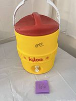 Front view showing Igloo logo, spigot, yellow body, red lid, white handle