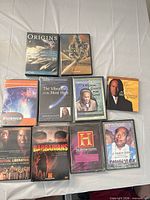 All eleven sealed DVDs and audio CDs laid out on table