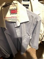 Three shirts on hangers showing colors and collars