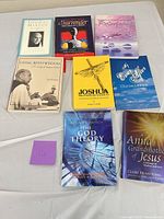 All eight paperback books laid out on table