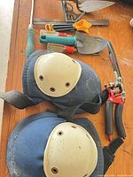 Overall view showing knee pads, pruning saw, pruners, trowels, combination square, screwdrivers