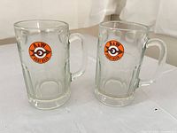 Front view of two A&W glass mugs showing logos and overall condition