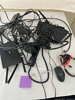 Pile of router, cable boxes, antennas, power strip and cables