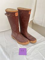Front view showing both boots, logo patches, toe shape, tan trim, scuffs