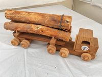 Full view of wooden log truck with logs on flatbed