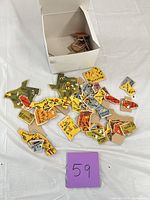 Box with numerous multicolor wooden state cutouts spread on table, showing quantity and overall condition
