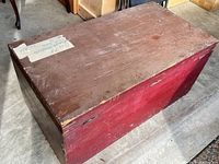 Closed chest showing red painted sides and brown top