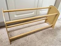 Full view of wooden shoe rack showing three dowels and side panels
