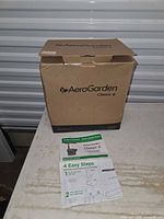 Closed AeroGarden Classic 6 retail carton with instruction sheet visible