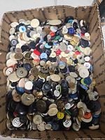 Cardboard box filled with assorted loose buttons