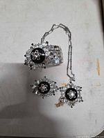 Cuff bracelet, brooch and necklace with matching rhinestone starburst designs displayed together