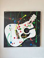 Full view of canvas showing white guitar shape, colourful splatter paint, 3D guitar parts