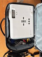 Projector in carrying case, top view showing control buttons and Vankyo branding