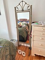 Full view of freestanding mirror next to dresser