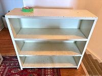 front view of white three-shelf wooden bookcase