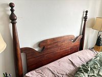 Full front view of solid wood headboard leaning behind mattress
