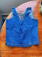 Front view of denim vest showing lace-up detail
