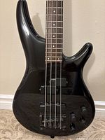 Front view of black Soundgear bass showing body, pickups, bridge, controls, neck, fretboard