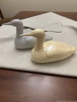 Both ceramic loon sculptures side by side