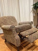 Recliner fully extended showing paisley upholstery and wooden legs