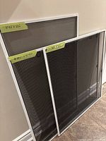 Two larger screens and one midsize screen leaned against wall showing overall appearance