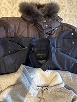 All three coats laid out showing materials and colors