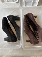 Black and brown suede pumps inside storage bins