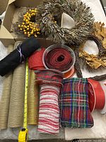Group view of wreaths and ribbon rolls on table