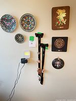 All items mounted on wall: four cloisonné plates and two velvet pendants visible