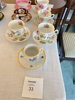 Group view of assorted teacups and saucers on table