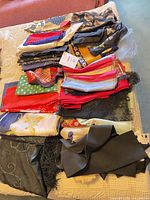 Stack of assorted scarves laid out on bed